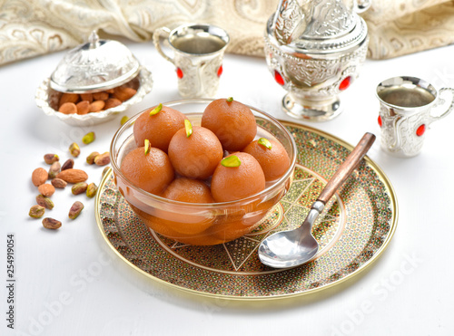 Gulab Jamun or Gulab Jaman in crystal bowl with arabian crockery photo