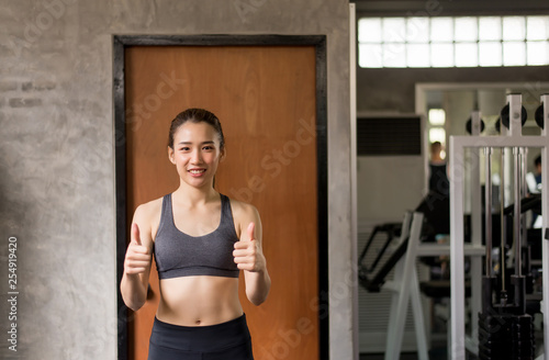 Sporty beautiful asian women posture standing and lifting thump up,Happy and smiling