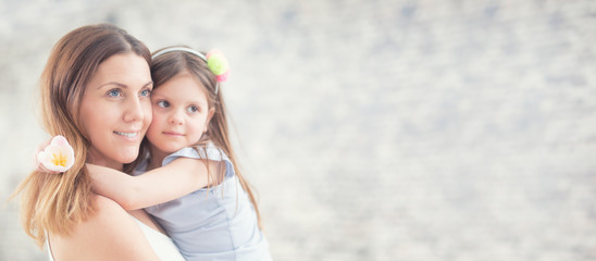 Happy mother's day concept. Portrait of loving mother with her daughter on her hands. Panoramic banner with copy space.