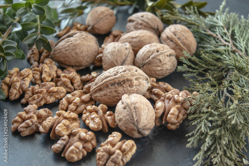 Walnut kernels near whole nuts on a black background.