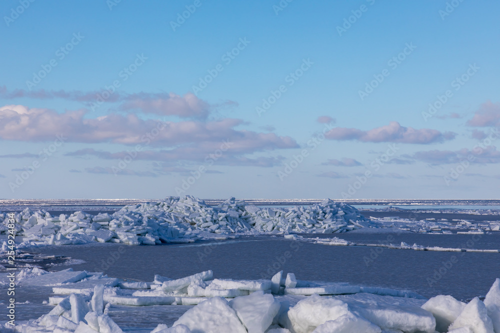 Fototapeta premium Seaside with frozen and melting ice with rocks