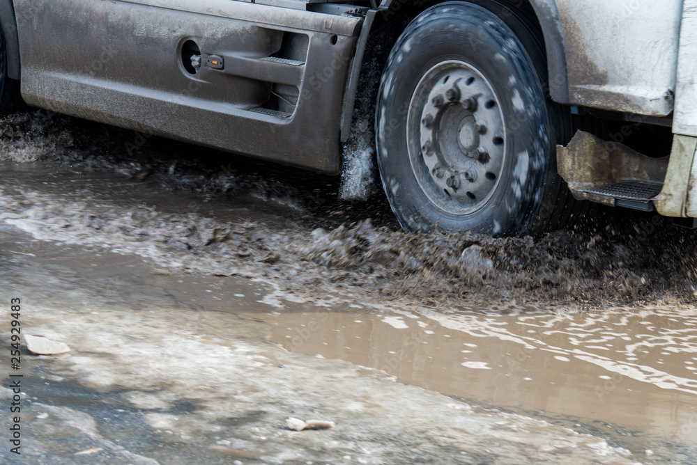 dirty wave of spray from under the wheels of a truck. Water on the road. Spray from under the wheels of cars. dirty wave of spray from under the wheels of a truck. Water on the road. Spray from under the wheels of cars.