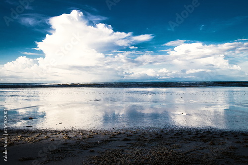 Scenery of the clouds in blue sky and sea with the beach in the evening time