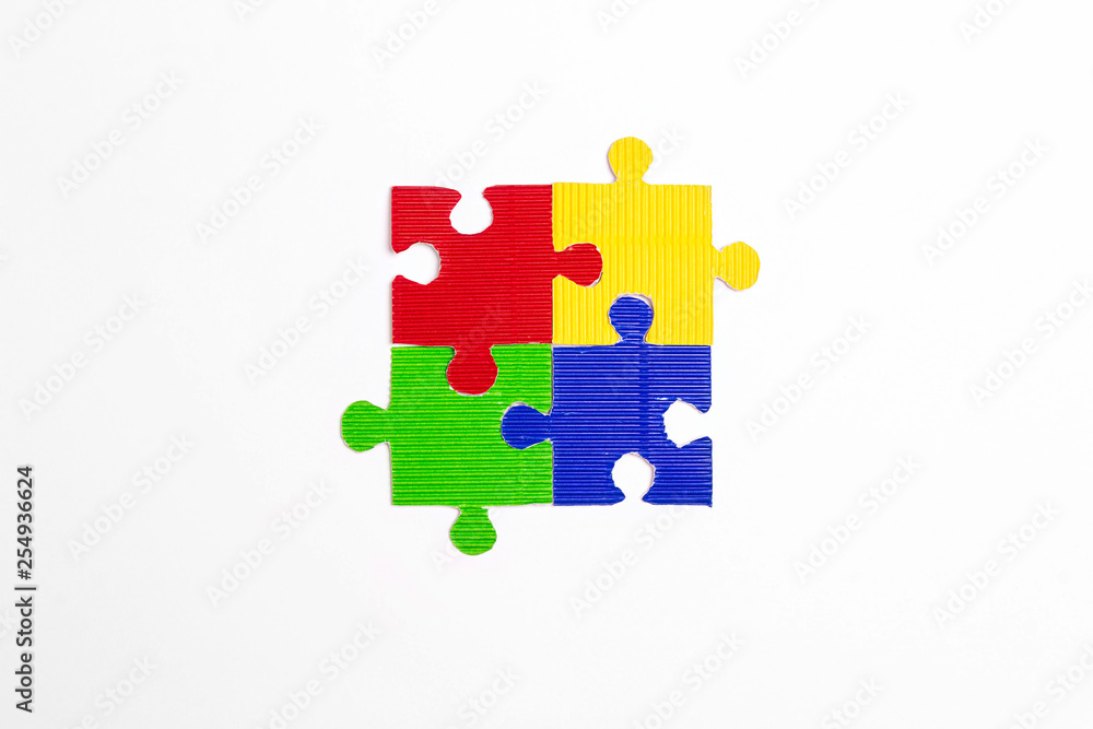 Four colored puzzle pieces on a white background. Autism Awareness Day.