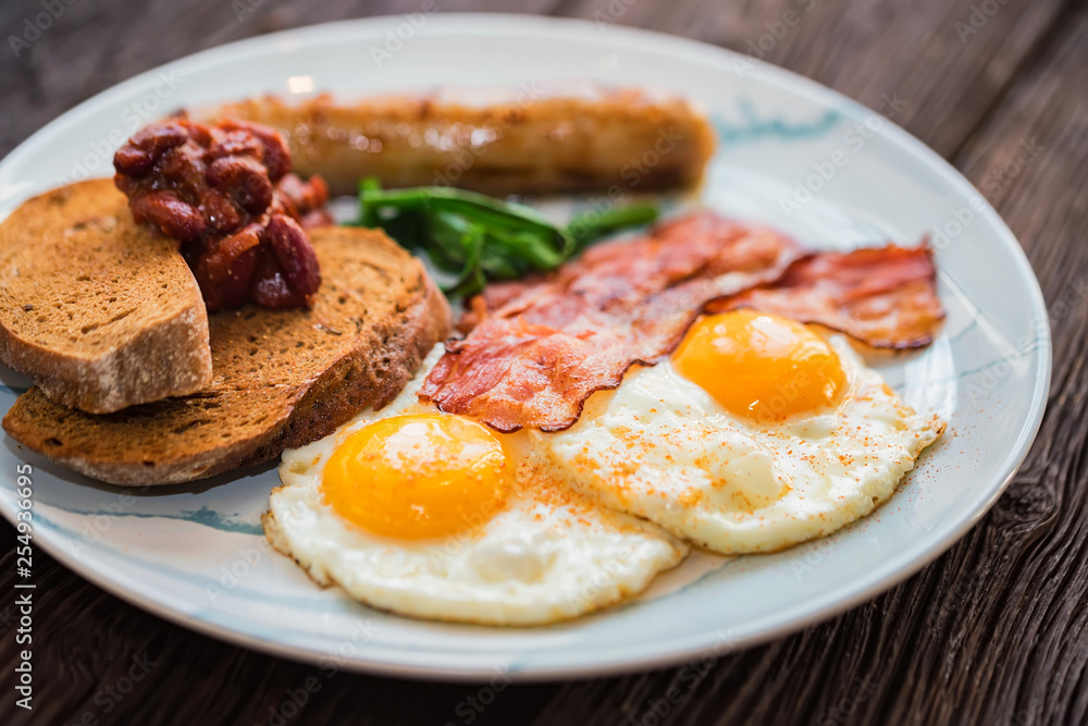 Typial breakfast with eggs, bacon and sausage on plate Typial breakfast with eggs, bacon and sausage on plate