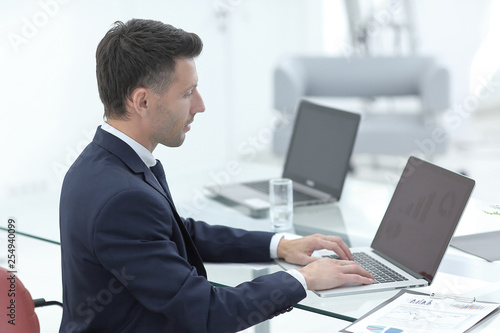 Young businessman working with laptop in office