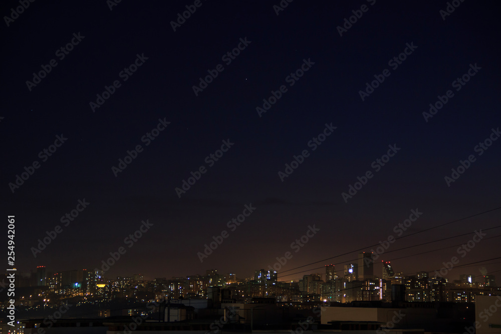 City skyline at night. Amazing panoramic view of modern city.Construction site with cranes on new residential areas.Stars on dark blue sky City skyline at night. Amazing panoramic view of modern city.Construction site with cranes on new residential areas.Stars on dark blue sky