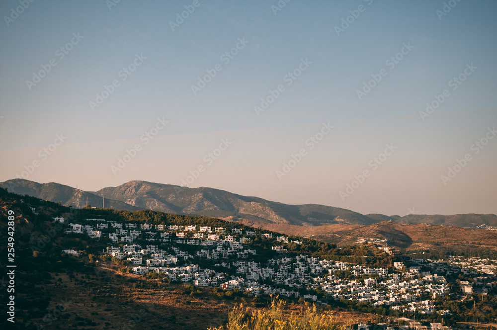 Typical white, cubic Bodrum houses in Turkey with a sea view, during sunset, summer