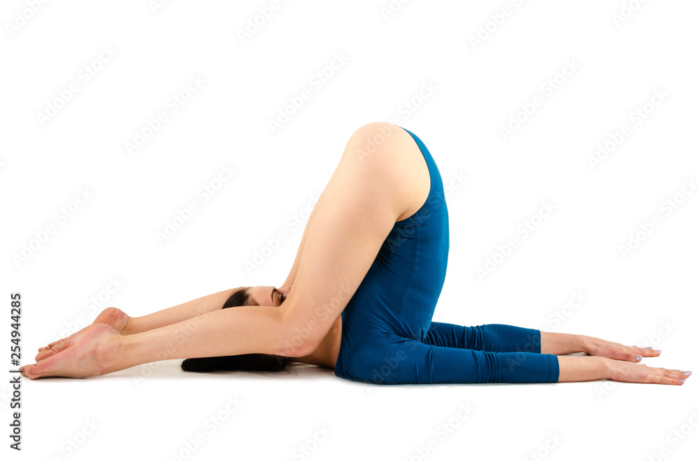 Beautiful slim girl in a blue bodysuit yoga trainer does assans.
