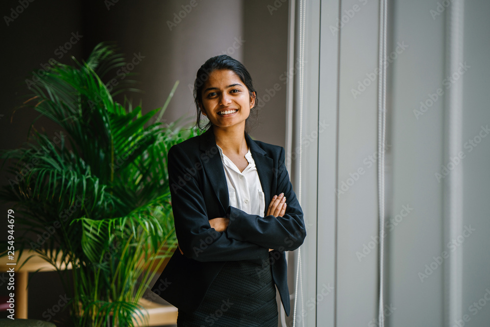 Portrait of a beautiful businesswoman standing in the conference center next to a glass window. She wears a black suit and pants, making her look so professional. Portrait of a beautiful businesswoman standing in the conference center next to a glass window. She wears a black suit and pants, making her look so professional.