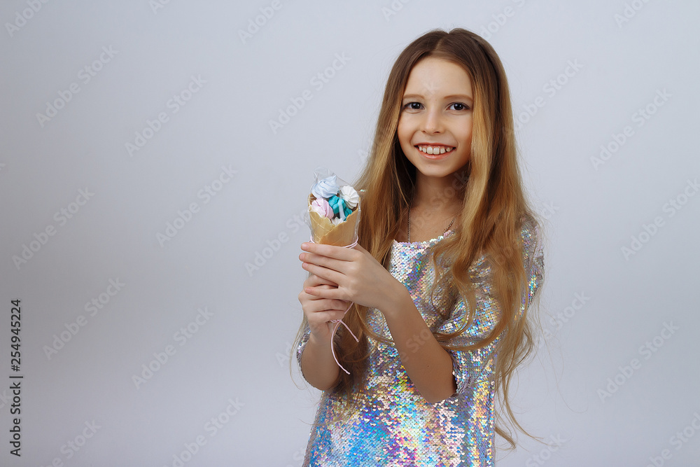 beautiful girl smiles and holds a lolly in her hands. a marshmallow long blond hair. on a white background. beautiful girl smiles and holds a lolly in her hands. a marshmallow long blond hair. on a white background.