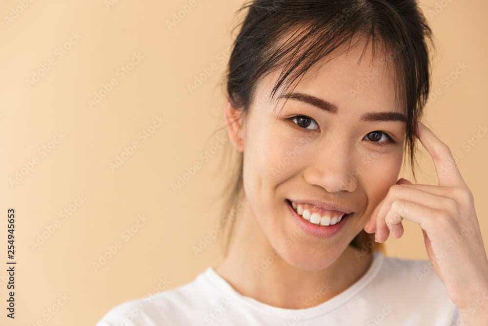 Portrait closeup of cheerful asian woman wearing basic t-shirt smiling and looking at camera Portrait closeup of cheerful asian woman wearing basic t-shirt smiling and looking at camera