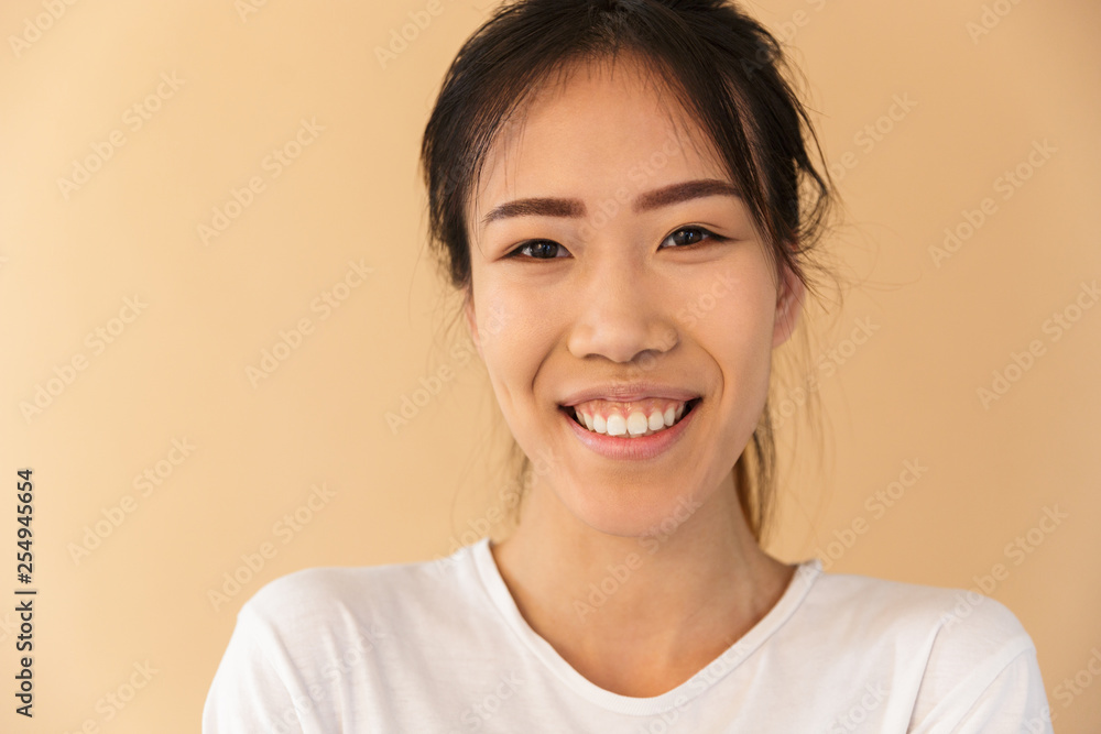 Portrait closeup of optimistic asian woman wearing basic t-shirt laughing and looking at camera Portrait closeup of optimistic asian woman wearing basic t-shirt laughing and looking at camera