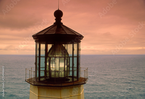 The lamphouse of Cape Meares Lighthouse with the Pacific Ocean off the Oregon coast on a cloudy day