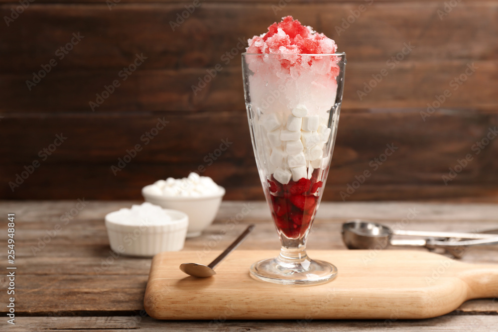 Glass of snow ice cream with raspberry and marshmallow on table against wooden background. Space for text Glass of snow ice cream with raspberry and marshmallow on table against wooden background. Space for text