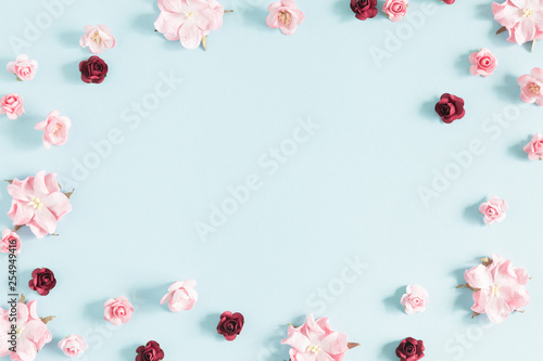 Flowers composition creative. Purple and pink flowers on pastel blue background. Flat lay, top view, copy space
