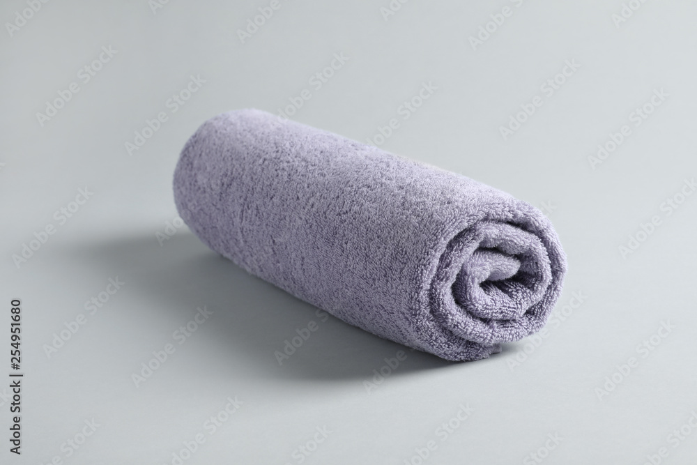 Fresh fluffy rolled towel on grey background Fresh fluffy rolled towel on grey background
