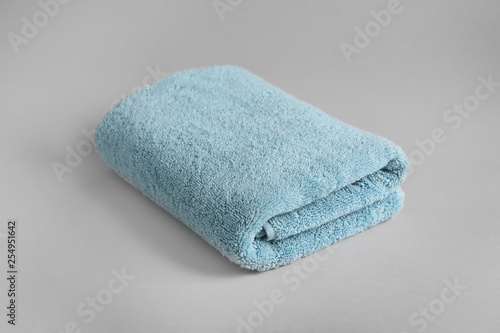 Fresh fluffy folded towel on grey background