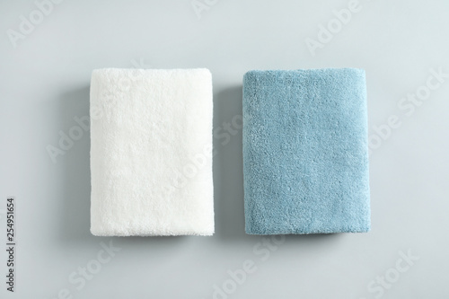 Fresh fluffy folded towels on grey background, top view. Mockup for design
