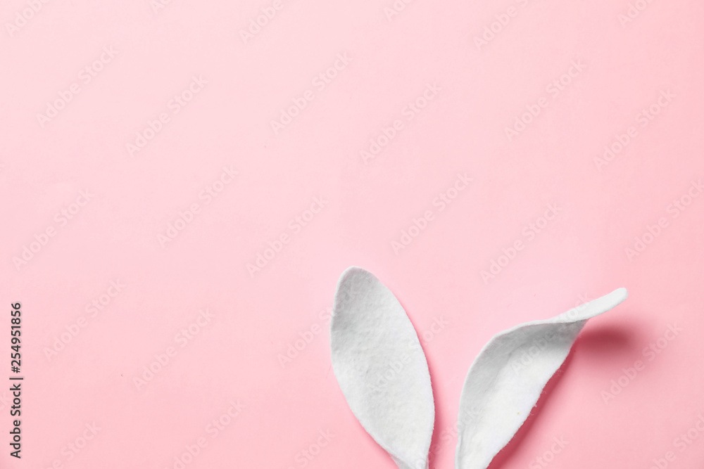 Funny Easter bunny ears on color background, top view with space for text Funny Easter bunny ears on color background, top view with space for text