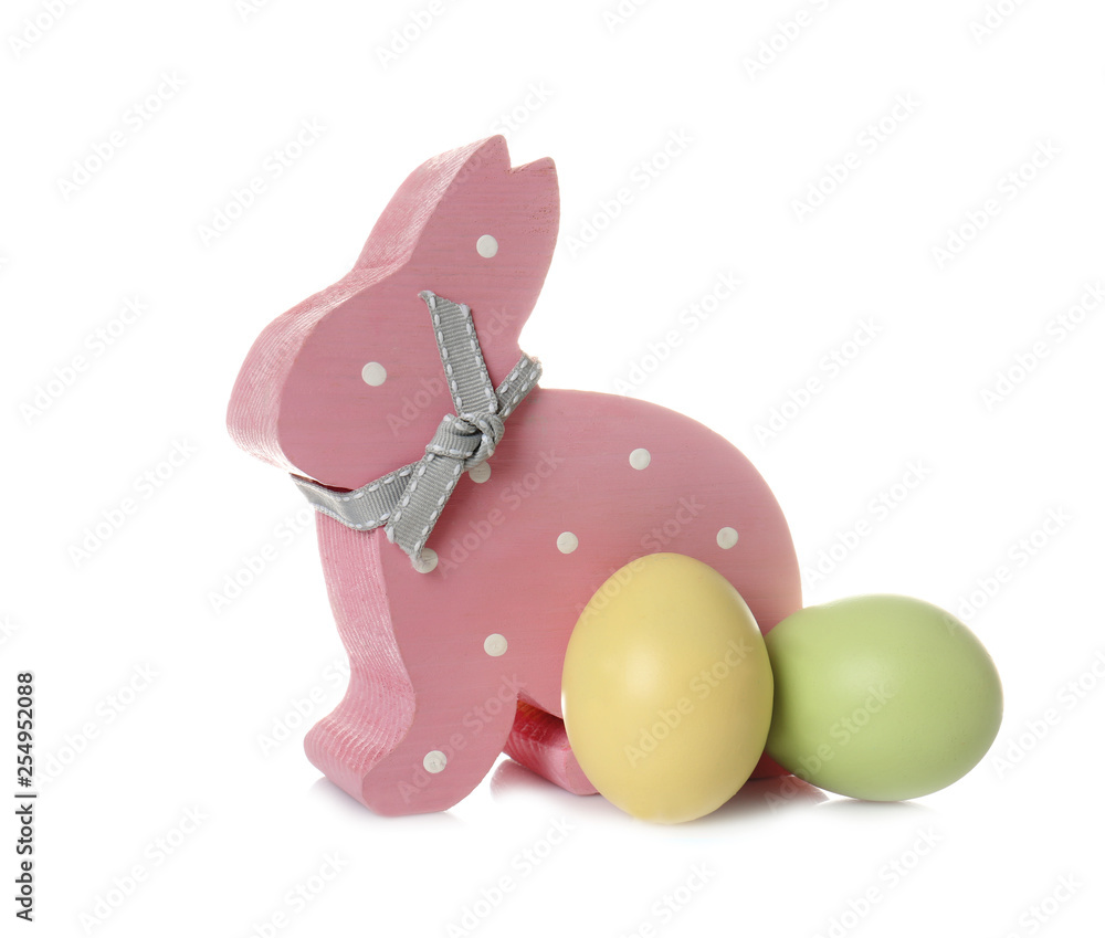 Obraz Cute wooden Easter bunny and dyed eggs on white background