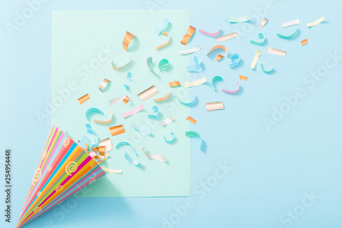 birthday hat with confetti on paper background