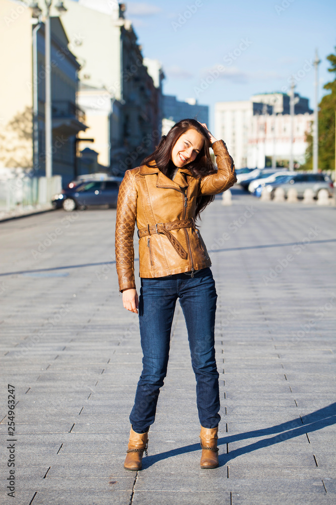 Young happy woman in brown leather jacket