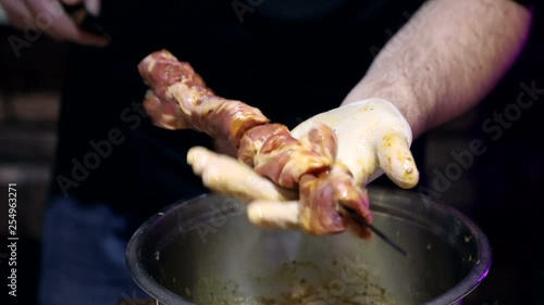 The chef in the restaurant Nanhu pieces of meat on chomper. Preparing skewers before grilling. photo