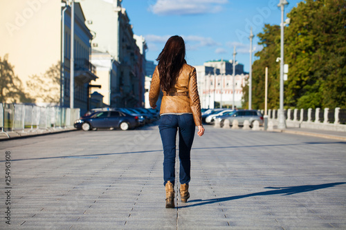 Young happy woman in brown leather jacket