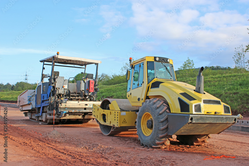 Roller and asphalt paver on a construction site Roller and asphalt paver on a construction site