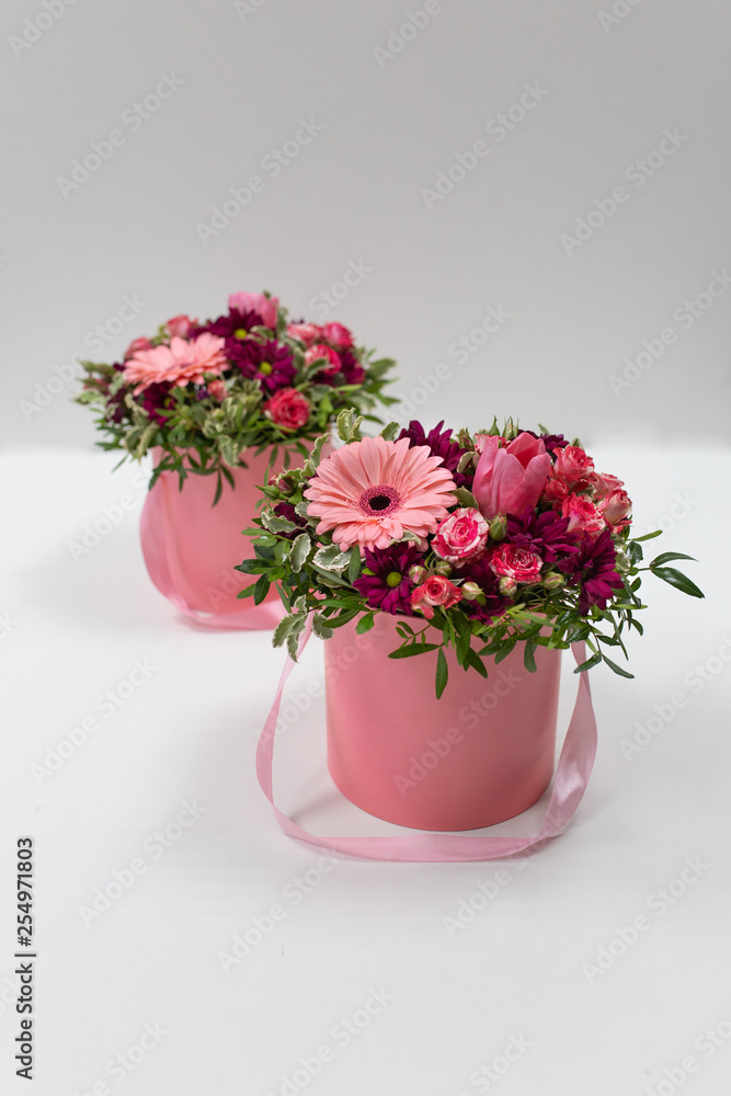 custom made wallpaper toronto digitalAn impressive pairing composition of fresh flowers (Rose, Gerbera, Tulip) (colors: beard, pink, green, white) in a pink cardboard round hat box on a light background
