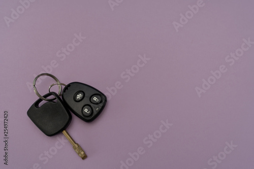 Close-up. Auto key and remote above on the left on purple background. Success in business. Car owner