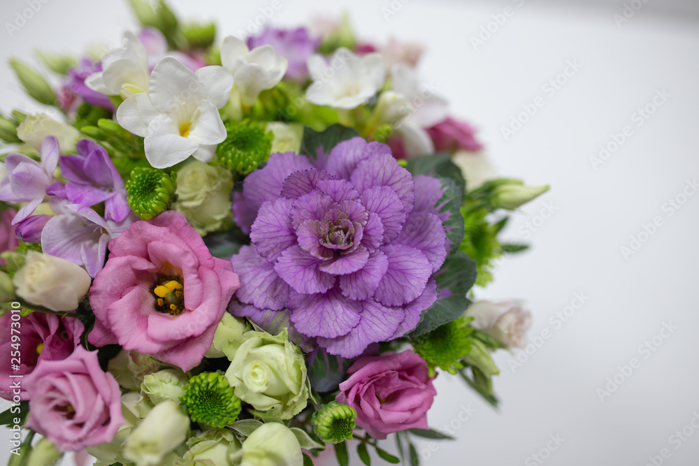 Wonderful flower arrangement (white, lilac, pink, light green color) in a white hat box on a light background