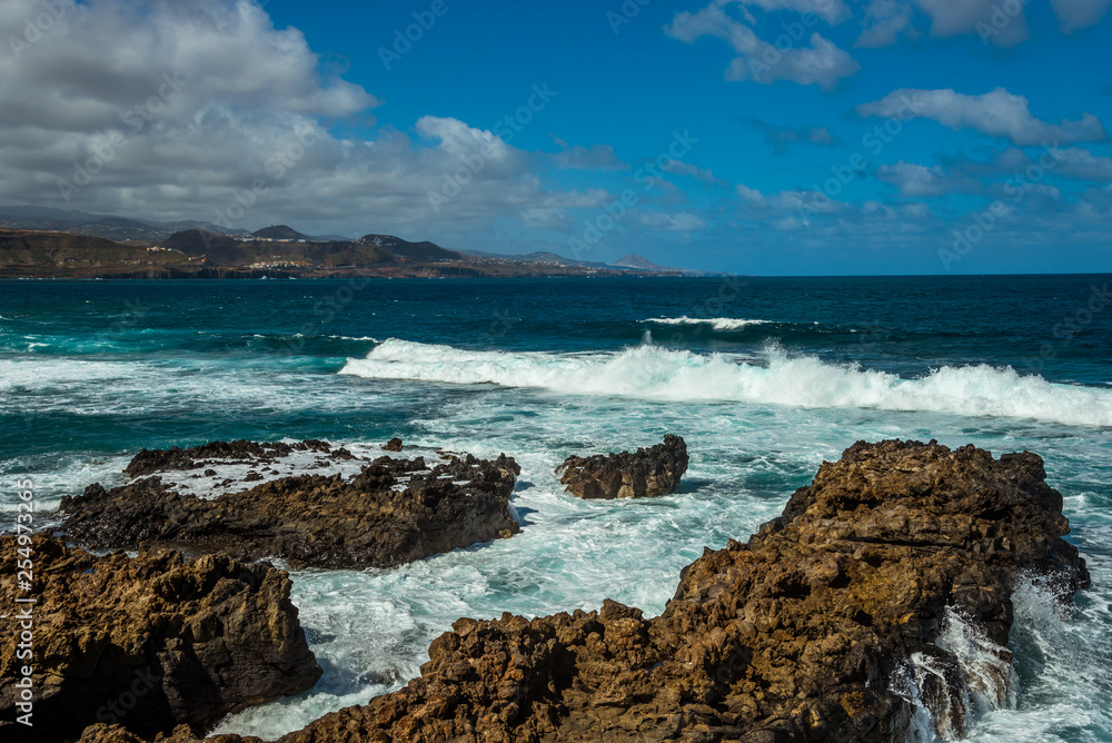 Tourism and travel. Windy day on the ocean. Rocky coast. Canary Islands, Gran Canaria, Atlantic Ocean. Tropics