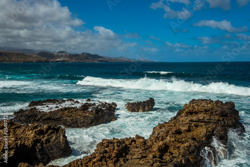 Tourism and travel. Windy day on the ocean. Rocky coast. Canary Islands, Gran Canaria, Atlantic Ocean. Tropics