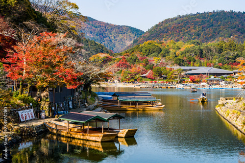 KYOTO, JAPAN - NOVEMBER 26, 2018: Boatman punting the boat for tourists to enjoy the autumn view along the bank of Hozu river in Arashiyama Kyoto, Japan