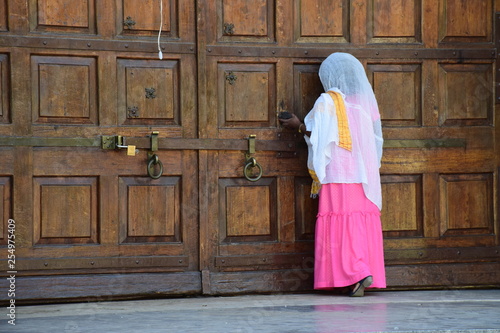 Betende Frau an einer Holztüre photo