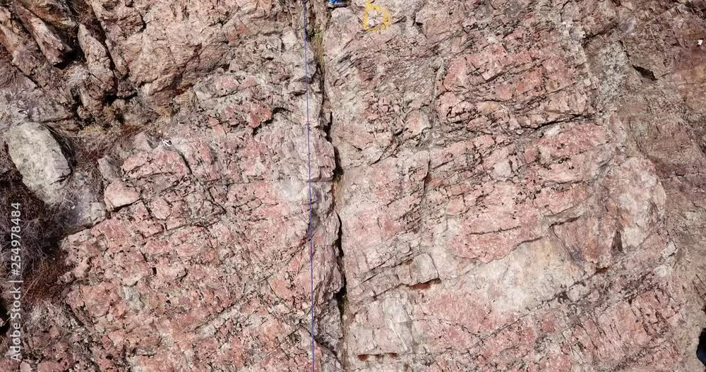 Climber climbs the rock. Girl and boy climb the rock. Rock climbing lessons. Rocky cliff. Winter nature. Drone footage. Extreme sport. A group of people trained climbing. Trees without leaves and gras Climber climbs the rock. Girl and boy climb the rock. Rock climbing lessons. Rocky cliff. Winter nature. Drone footage. Extreme sport. A group of people trained climbing. Trees without leaves and gras