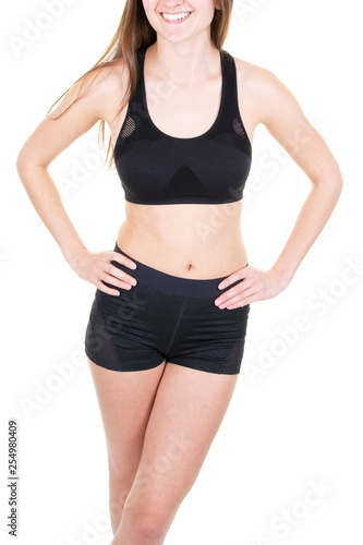 Close up fit female body wearing sport tight panties and bra holding hands on waistline isolated on background