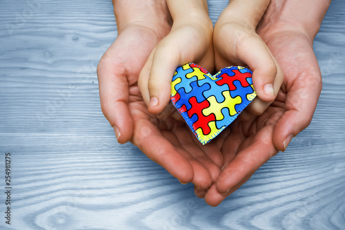 Photo World Autism Awareness day, puzzle or jigsaw pattern on heart with autistic chil