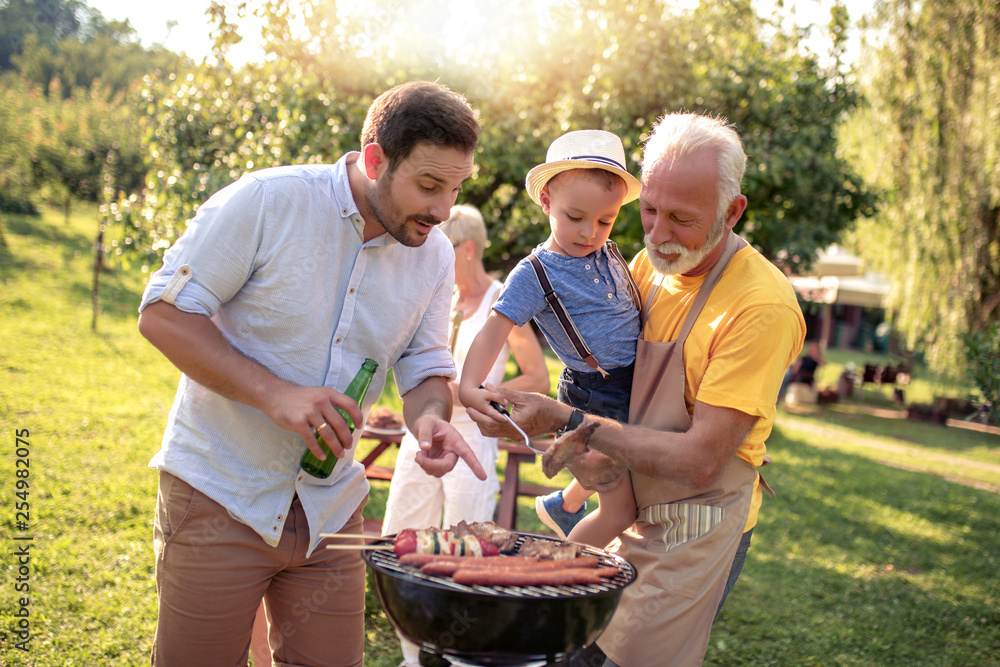 Happy big family standing around the grill Happy big family standing around the grill
