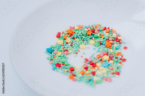 Selective focus Festive abstract multicolored candy sprinkles. Yellow red green orange blue circles, doodles, flowers, neon blurred. Easter, birthday greeting card or web banner concept