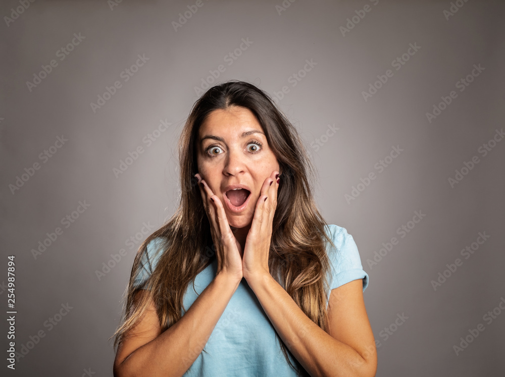 portrait of woman surprised on a gray background portrait of woman surprised on a gray background