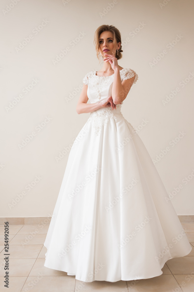 Fashion bride in gorgeous wedding dress studio portrait. Beautiful model with bridal makeup and hairstyle in marriage lace dress. Fashion bride in gorgeous wedding dress studio portrait. Beautiful model with bridal makeup and hairstyle in marriage lace dress.