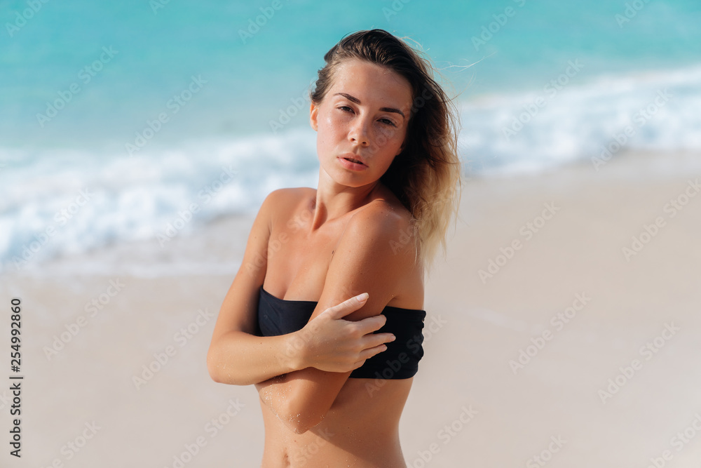 Portrait of sensual tanned girl in black swimsuit on sandy beach Portrait of sensual tanned girl in black swimsuit on sandy beach