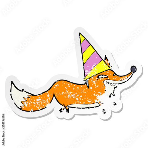 distressed sticker of a cartoon sly fox in party hat