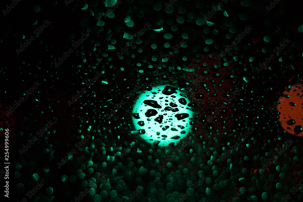 Obraz premium Colored drops on a glass at night