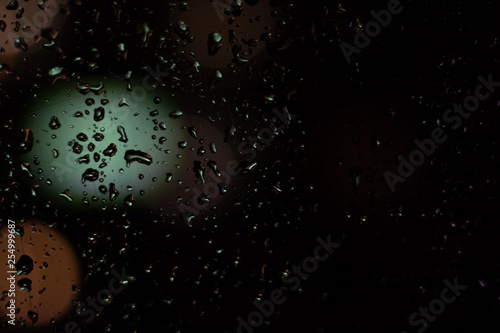 Colored drops on a glass at night