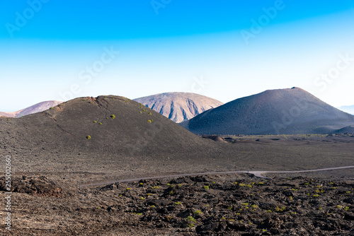 Timanfaya National Park, mountains of fire Lanzarote, Canary Islands, Spain. Unique panoramic view of spectacular lava river flows from a huge volcano crater creates a lunar landscape on planet earth.