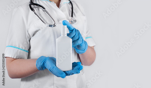 Fototapeta Naklejka Na Ścianę i Meble -  A doctor woman with stethoscope holding a bottle with some mixture. Medical and scientific concept.